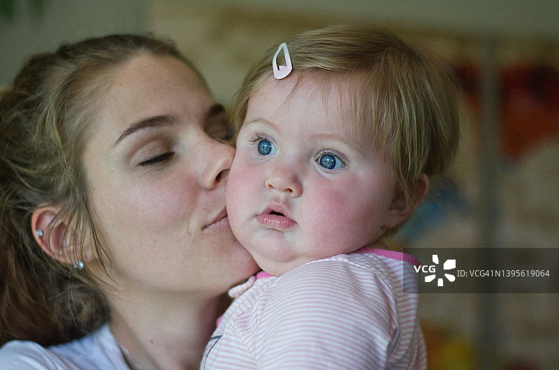 年轻母亲亲吻婴儿肖像图片素材