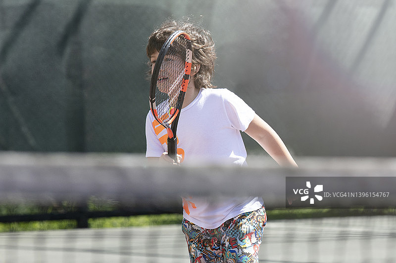 欢快的孩子们在球场上打网球图片素材