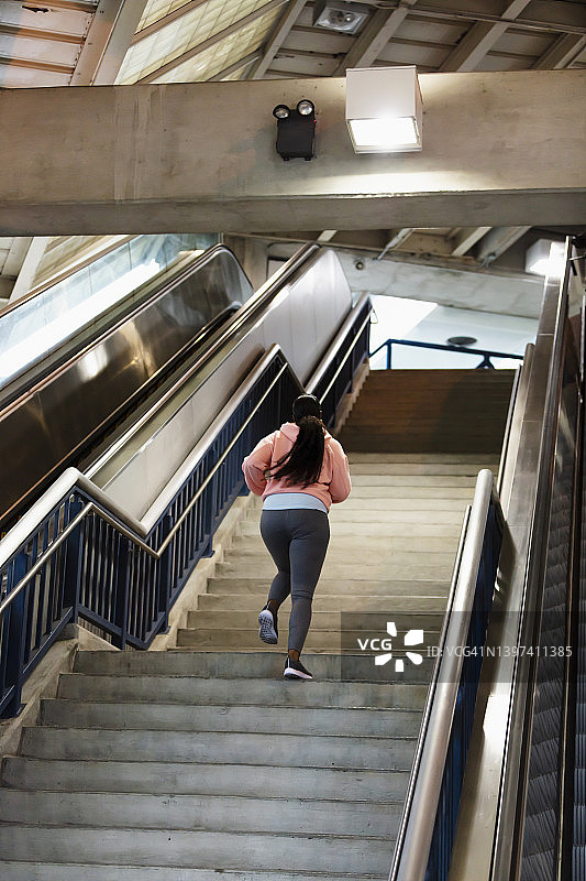 非裔美国女人跑上陡峭的混凝土楼梯图片素材