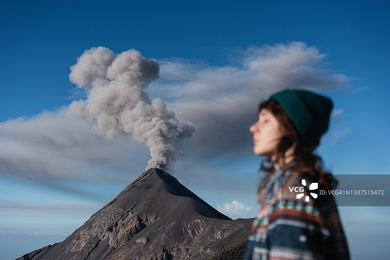 一名妇女站在危地马拉富埃戈火山爆发的背景上图片素材