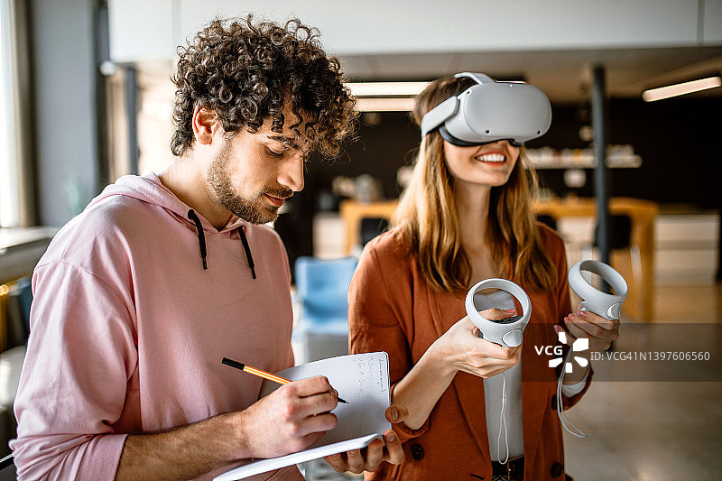 一群大学生在办公室里使用VR模拟头戴式设备，尽情玩乐图片素材