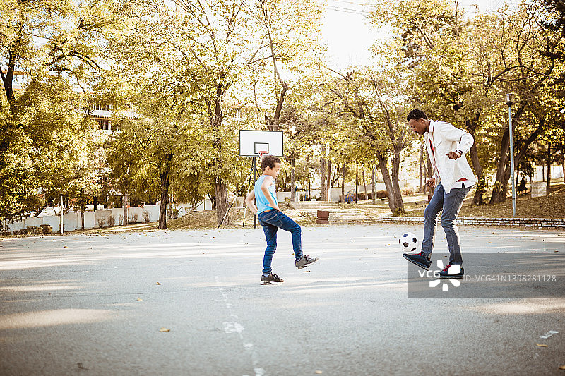 父亲和儿子在踢足球图片素材