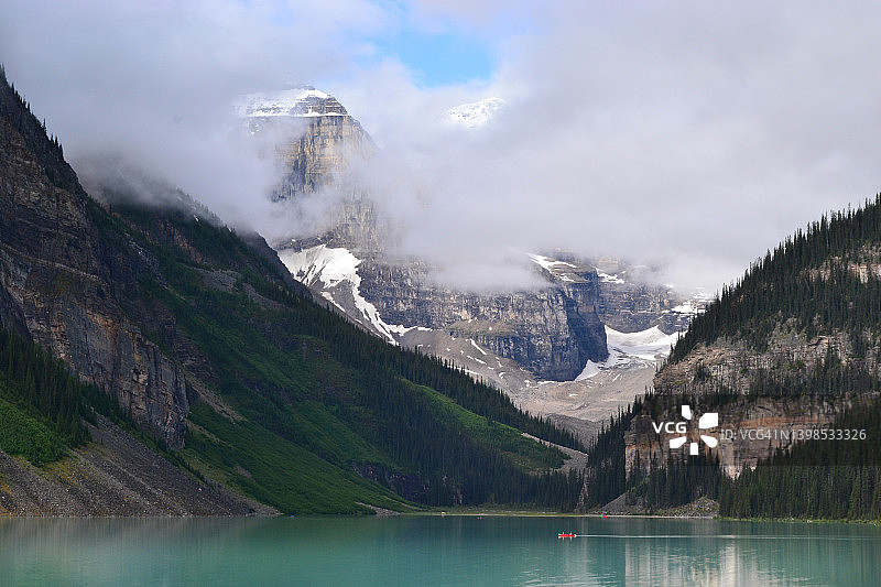 加拿大阿尔伯塔省班夫国家公园，绿松石色的露易丝湖，红色的小船和覆盖雪山的云朵图片素材