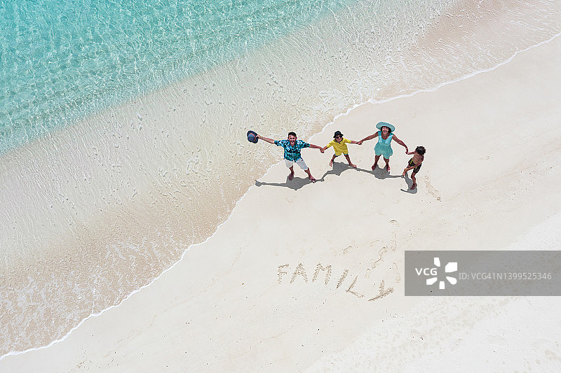 幸福的家庭和两个小男孩在海滩上玩得很开心，俯瞰图片素材