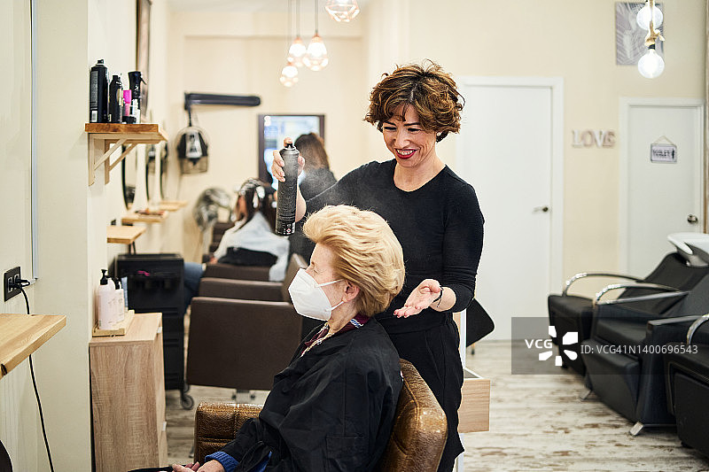 理发师用发胶为客户梳头。图片素材