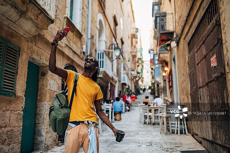 一个微笑的拉丁美洲黑人喜欢在老城区散步，并自拍照片图片素材