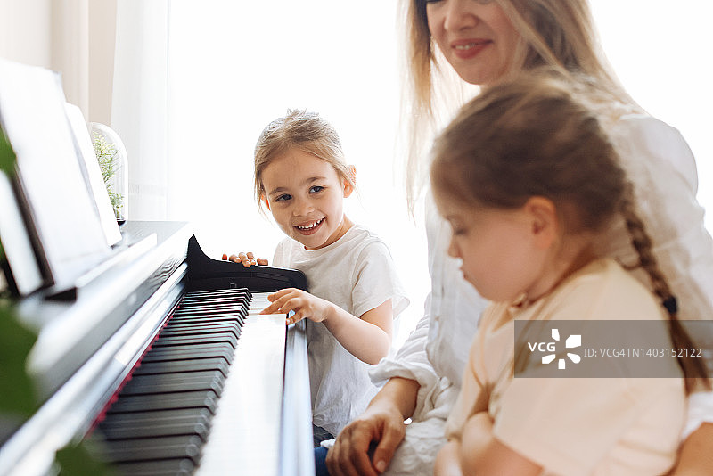 青年钢琴教师教女生学钢琴，音乐教育理念图片素材
