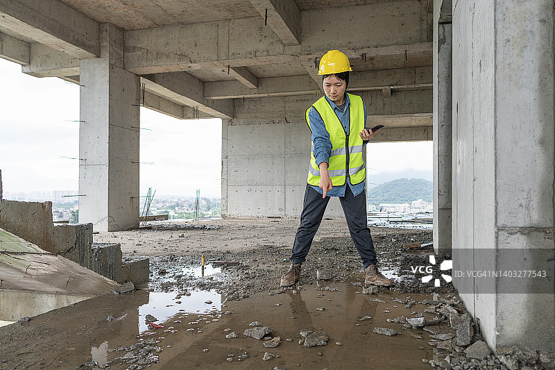 一位亚洲女工程师正在检查建筑工地的漏水情况图片素材