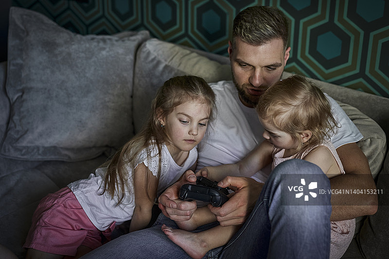 父亲带着女儿在家里玩游戏图片素材
