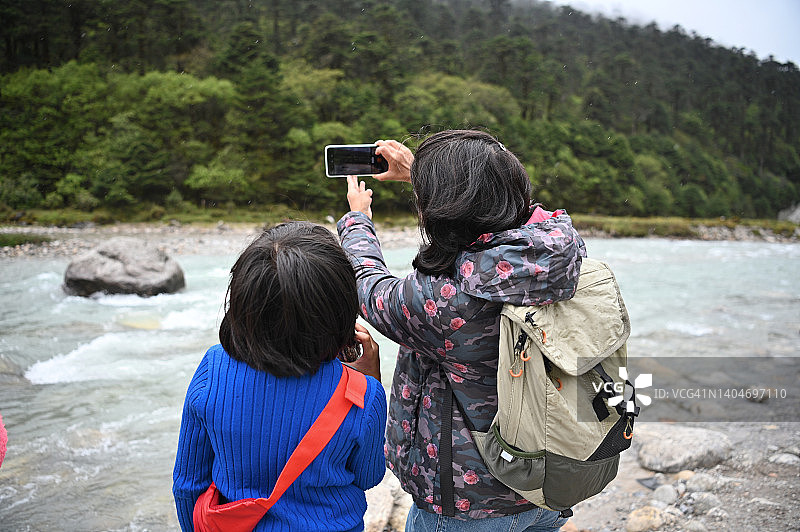 母女俩享受大自然，一起拍照留影图片素材