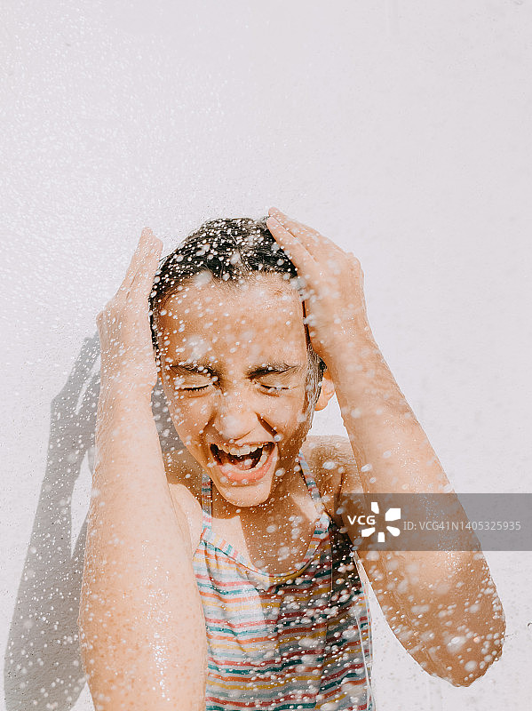 年轻的女孩享受户外淋浴图片素材