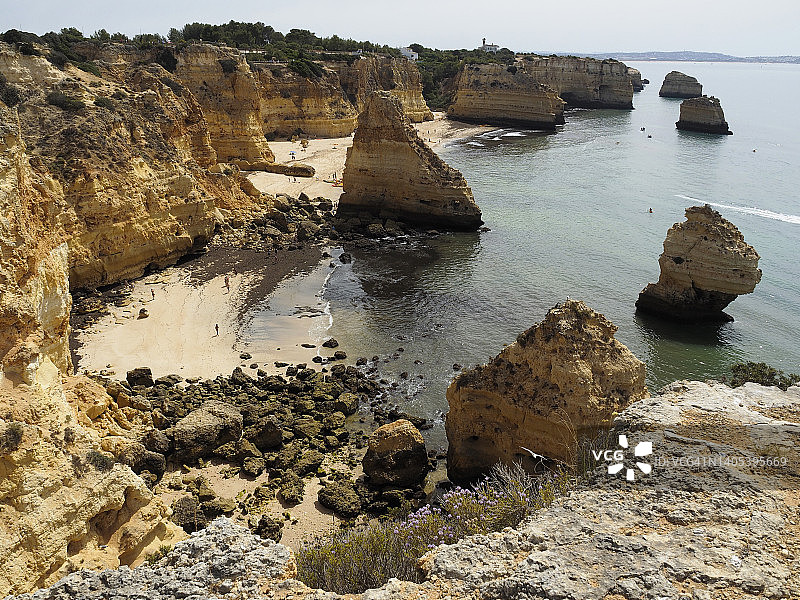 沿着“Percurso dos Sete Vales Suspensos”，Algarve，葡萄牙，Praia da Marinha沙滩和堆叠岩石图片素材