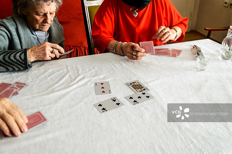 一小群老年人通过打牌来参加社交活动。图片素材