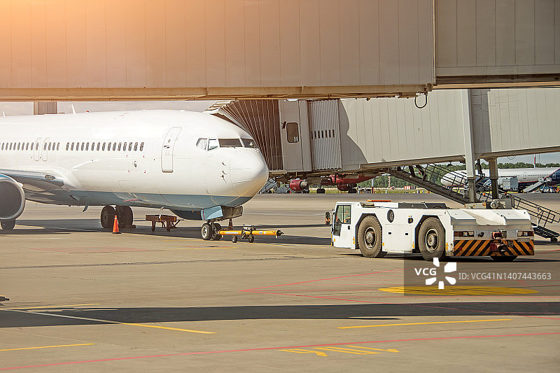 拖车推回准备将飞机拖到机场的停车处。图片素材