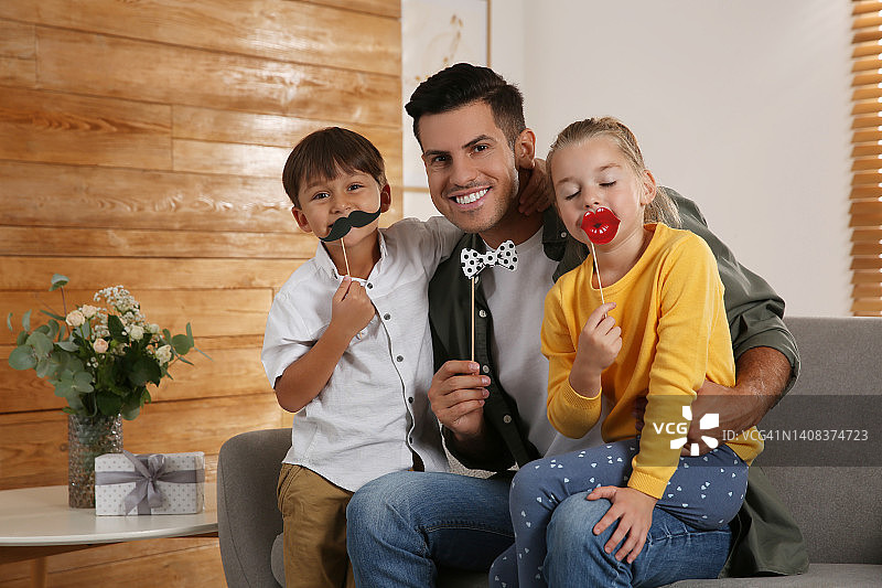 爸爸和他的孩子们在家里玩得很开心。父亲节快乐图片素材