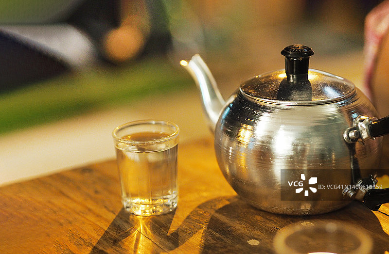 铝茶壶和热茶在透明玻璃图片素材