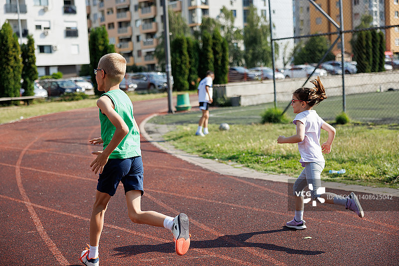 哥哥和妹妹在城市的跑道上跑步图片素材