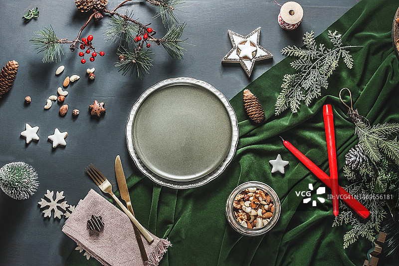 圣诞餐桌设置背景板，圣诞星，冷杉绿色，织物，餐具和装饰在灰色的背景图片素材