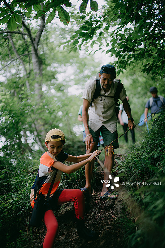 小女孩和她父亲在森林里徒步图片素材