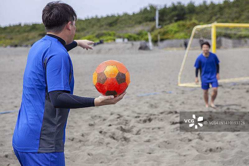 沙滩足球运动员掷界外球图片素材