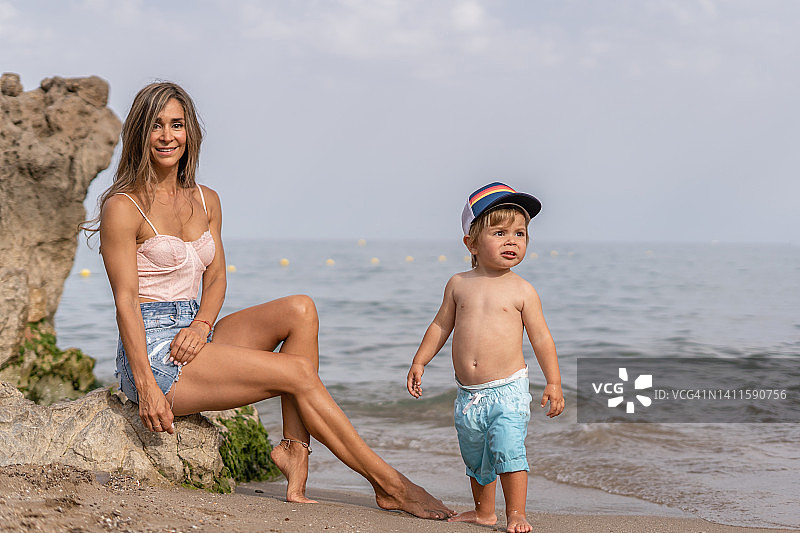 愉快的一家人在海滩上玩耍。暑假，妈妈和儿子在沙滩上玩耍图片素材