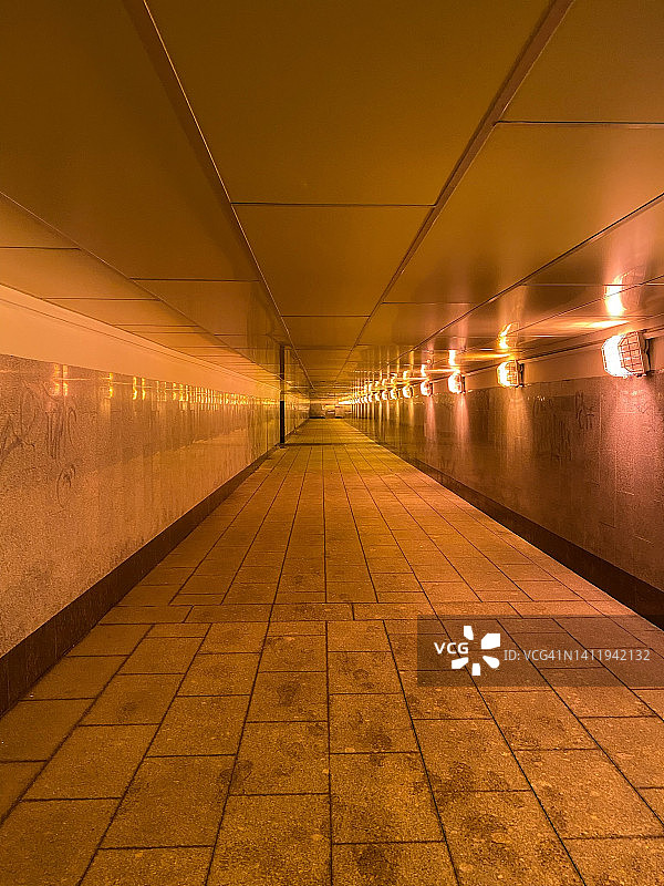 贴瓷砖的地下隧道，墙上有灯。地铁隧道图片素材