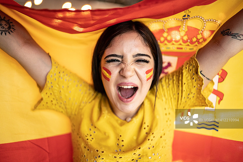 一名年轻女子举着西班牙国旗庆祝的画像图片素材