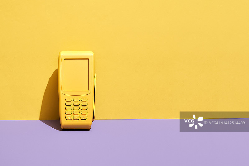 黄色信用卡POS终端上黄色和紫色的背景图片素材