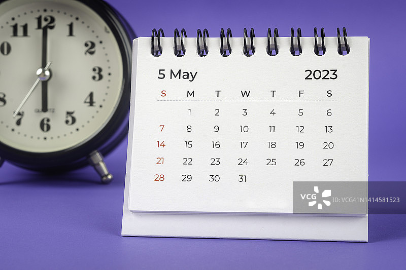 2023年5月是组织者计划和截止日期，桌子上有一个闹钟，背景是蓝色的。图片素材