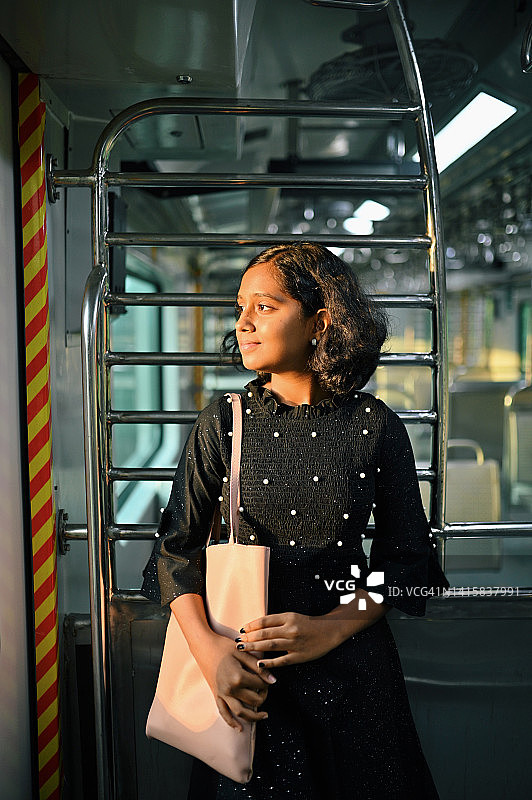 一个十几岁的女孩站在火车上的肖像图片素材