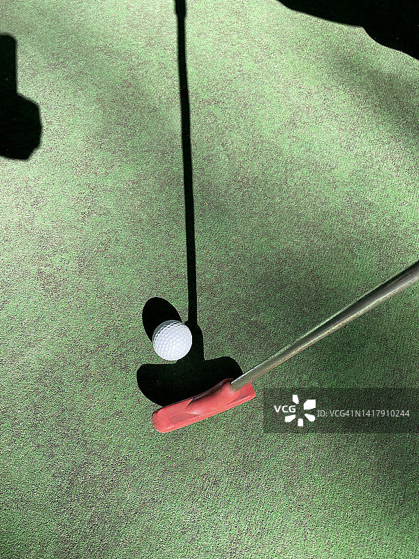 高尔夫球杆和球在一个绿色的背景，俯视图。图片素材