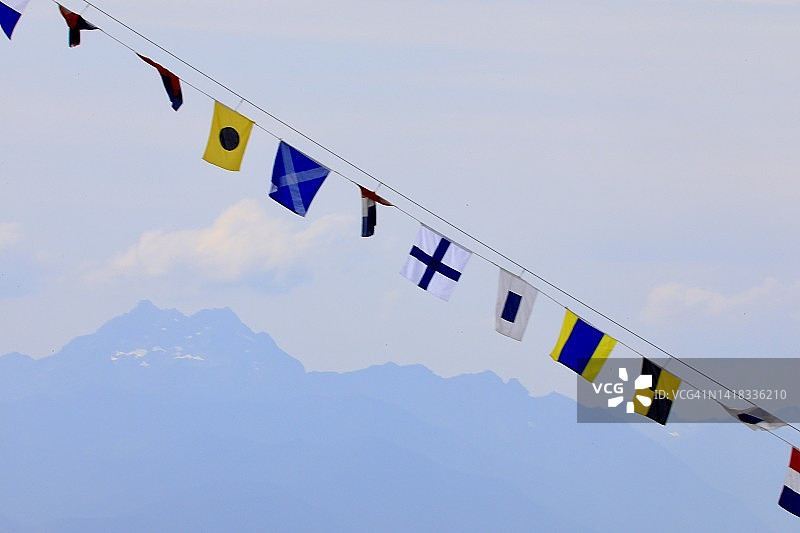 悬挂在航海船桅杆上的国际海事信号旗图片素材