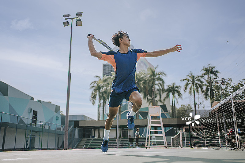 技术娴熟的中国亚洲网球选手在空中跳跃，完成一次扑救图片素材