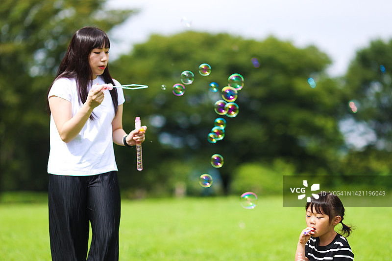 妈妈和女儿在公园里玩肥皂泡图片素材