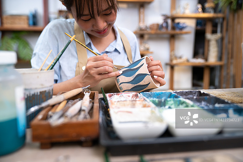 手工陶瓷手工上色采用毛笔上色，车间生产的陶瓷餐具产品上色图片素材