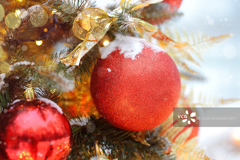 用金色、红色的球和花朵装饰的人造圣诞树树枝。特写镜头。传统城市户外圣诞市场。城市庆祝装饰图片素材