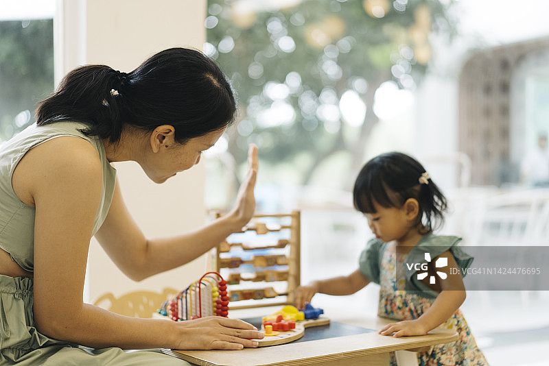 近距离拍摄积极情绪的亚洲母亲教女儿如何玩蒙特梭利玩具图片素材