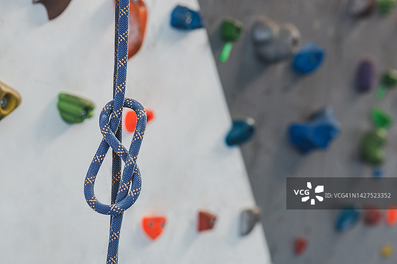 在室内攀岩墙上的彩色结实绳索上正确的安全结的特写。图片素材