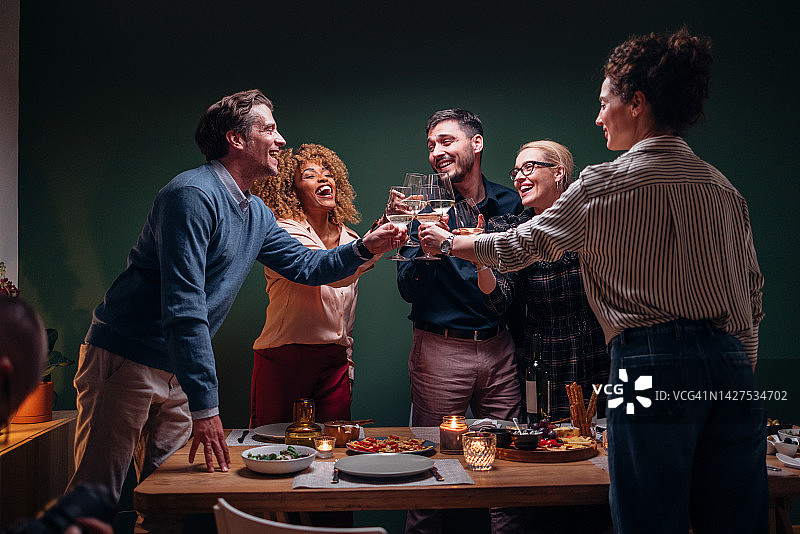 在晚宴庆祝活动中，微笑的朋友们举杯祝酒图片素材