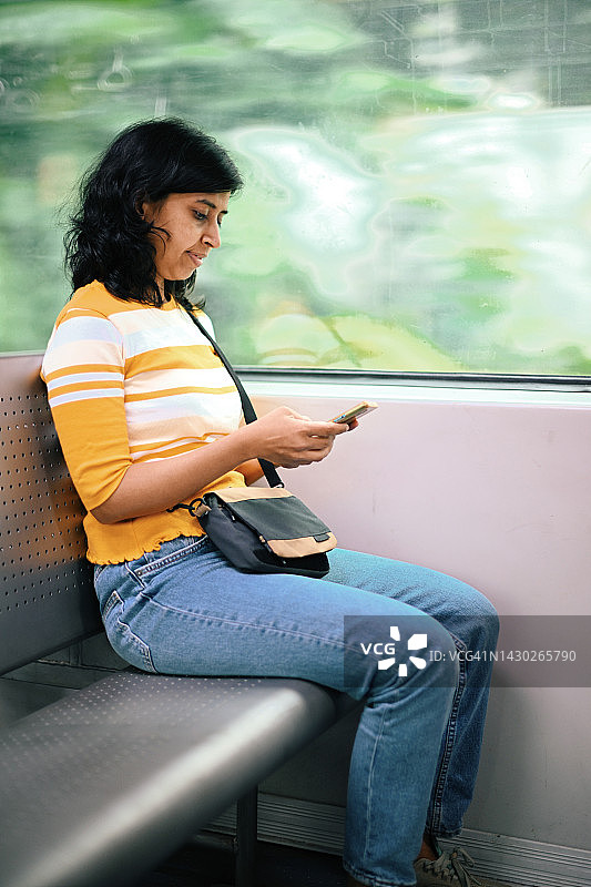 一名女子在火车上使用智能手机图片素材