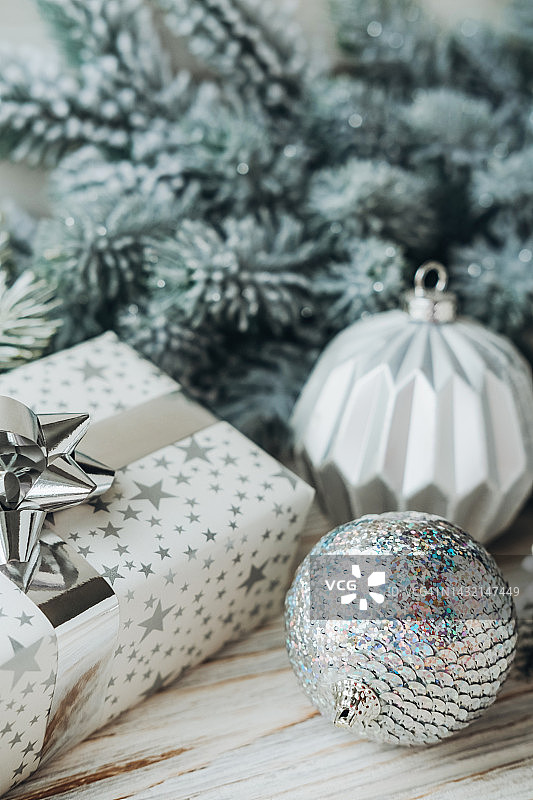 礼品盒，圣诞球在木表面杉木树枝。图片素材