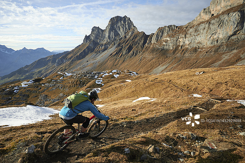 山地车骑手骑在崎岖的山脚下的狭窄小道上图片素材