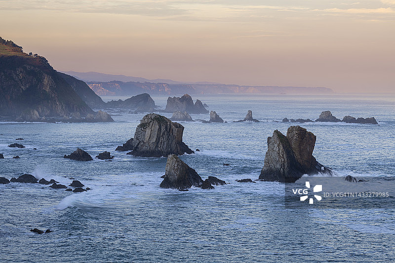 从Silencio海滩(Playa del Silencio)看日出时水中的岩石。Silencio海滩，Playe del Silencio, Cudillero, Asturias，比斯凯湾，西班牙，大西洋。图片素材