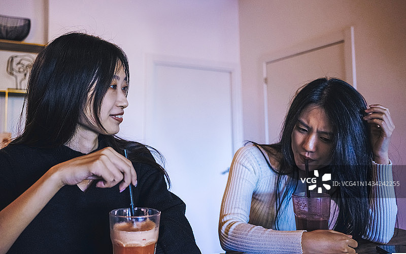 两个亚洲朋友在酒吧里喝冰沙图片素材