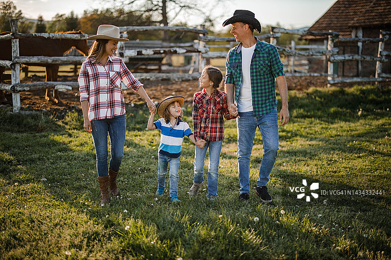 幸福的家庭在牧场散步。图片素材