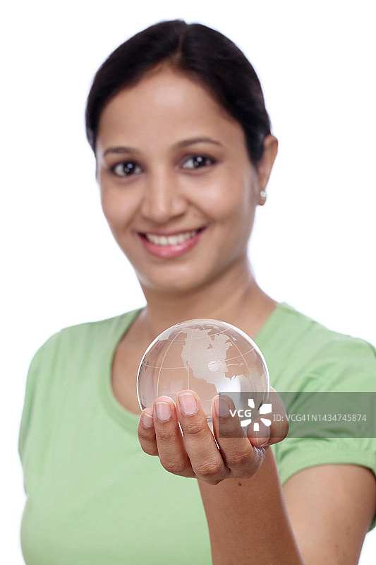 快乐的年轻女子在白色背景下拿着玻璃球图片素材