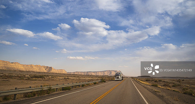 卡车行驶在美国犹他州空旷的道路上图片素材
