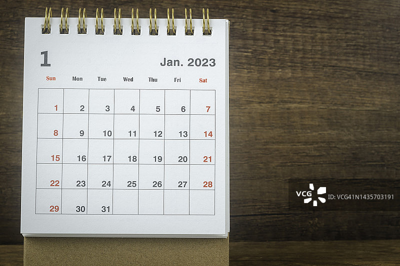 日历桌2023:一月是组织者用木桌背景计划和截止日期的月份。图片素材