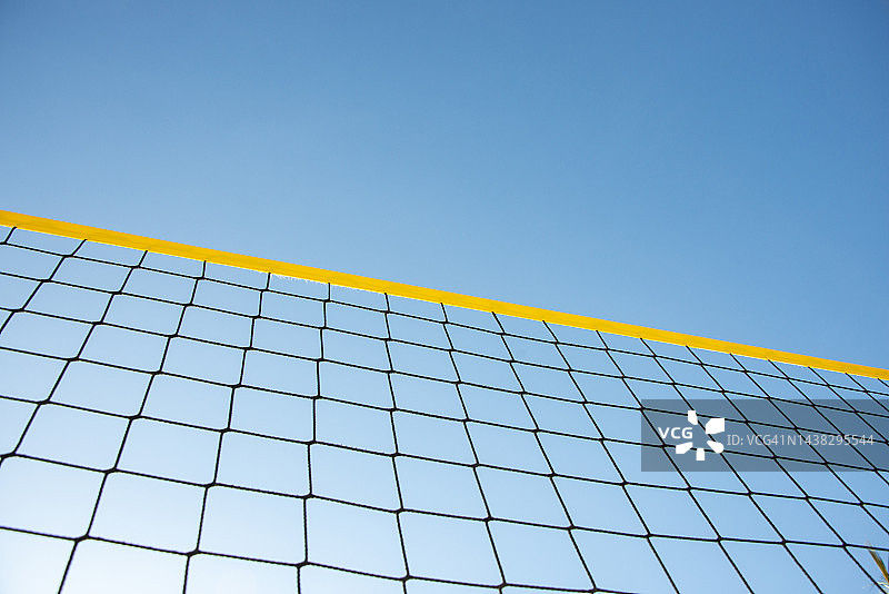 天空背景的沙滩排球网。夏季运动的概念图片素材