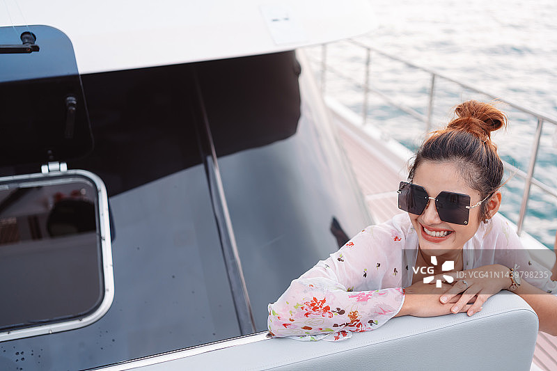 豪华游艇上的美女。尽情享受阳光，女人愉快的夏日海上旅行。周末活动生活方式图片素材